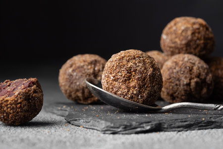 Decorating of artisan chocolate truffle candies with berry and fruit filling on dark background from confectionary. Handmade or handcrafted bonbons, chocolatier concept. Horizontal banner, copy spaceの写真素材