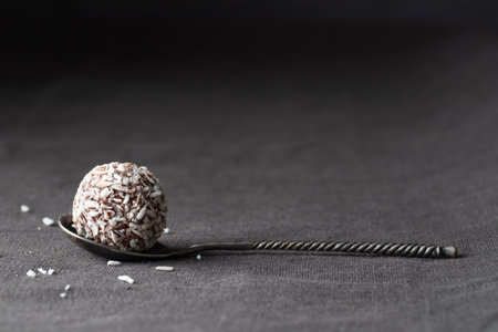 Artisan chocolate coconut truffle candy on dark background from confectionary. Handmade or handcrafted bonbon, chocolatier concept. Horizontal banner, copy spaceの写真素材