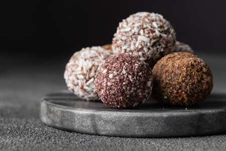 Assortment of gourmet handcrafted vegan chocolate truffle candies on dark marble background from premium confectionary. Handmade bonbons chocolatier concept. Horizontal banner with copy spaceの写真素材