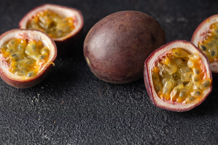 Passion fruits and its cross section with pulpy juice filled with seeds on black background. Horizontal banner photo with copy spaceの写真素材