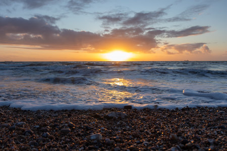 Colorful sunset over the English Channel. Beauty of the sea and ocean, pebbles beach of Normandy, France, Europe. High-quality photoの写真素材