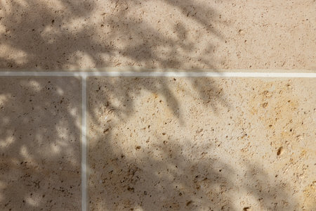 Beige travertine tile wall, natural limestone bricks in sunlight with shadow, background for wallpapers or web-banner designの写真素材
