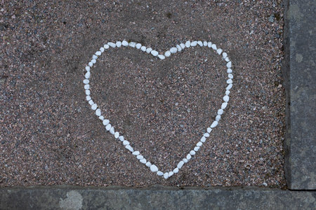 A heart shape formed from smooth stones is placed gently on a grave, symbolizing love and remembrance.の写真素材