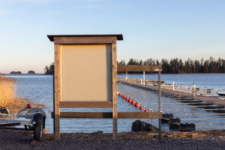Info stand in sea marina in spring, empty piers in a calm sea marina harbor, start of sailing and ferry season in Finland, Suomenojaの写真素材