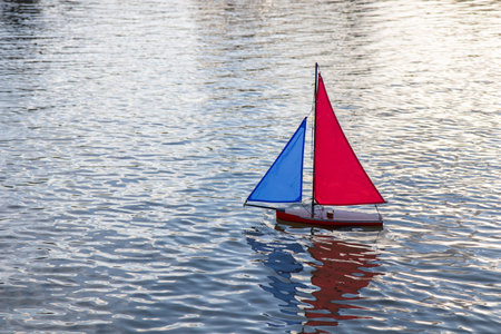 A small toy sailboat floats gently on the surface of calm water in the Luxembourg Garden Jardin du Luxembourg, Paris, Franceの写真素材