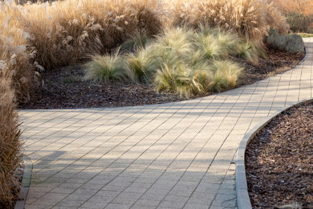 A stone-paved path winding through grass. The natural setting blends human design with landscape,...