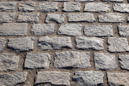A cobblestone pavement with irregular stone textures, creating a historic and charming surface in old European town, traditional and timeless backgroundの写真素材