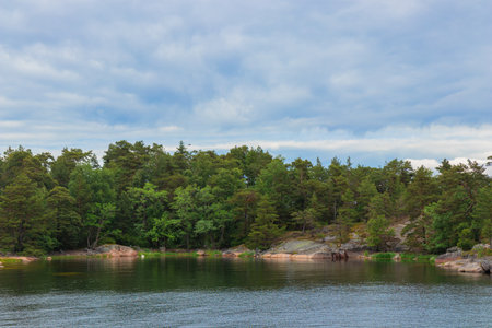 A peaceful coastal scene from a Finnish archipelago with pine trees, sea, and granite rocks. Protecting fragile island ecosystems and preserving the natural heritage. Jussaro, 2025の写真素材