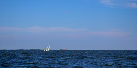 Sailing yacht with head genoa and mainsail glides through the sea in the Gulf of Finland against the...