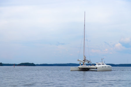 Modern catamaran sails smoothly over deep blue sea, under a clear sky. freedom, adventure, joy of exploring open waters on a perfect sailing day in a Baltic sea, Finlandの写真素材