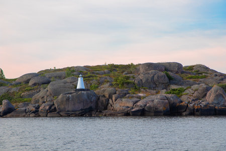 Marine channel marker on coastal rocks, indicating the edge of the channel. Coastal navigation aid in Baltic sea, highlighting safety, marine guidance, and rocky shorelineの写真素材