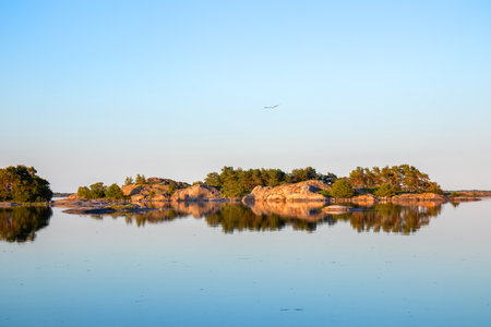 Northern coastal landscape of calm Baltic Sea with perfectly smooth water, clean, unspoiled marine environment, ecological preservation concept in Finlandの写真素材