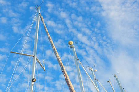 Wind indicator mounted on sailboat mast against sky. Sailing equipment showing wind direction and...