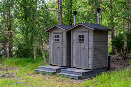 Public eco-friendly wooden WC in the Finnish forest, designed for sustainability and protection of...