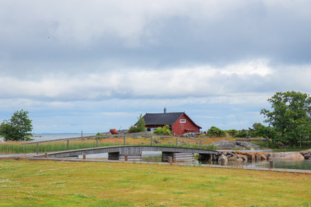Scenic wooden cottage in Finland. Traditional Nordic architecture, cozy rural atmosphere, surrounded by nature, peaceful landscape, and northern charmの写真素材