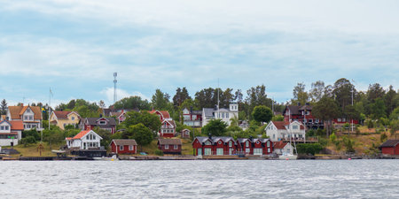 Charming Swedish houses along Stockholm fjord coast. Idyllic Nordic summer travel destination, perfect for vacation, relaxation, and exploring Scandinavian lifestyleの写真素材