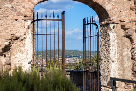 Arched gate to the castle in Borghetto, Italy - a medieval stone entrance framed by towers, showcasing historic architecture and the charm of the ancient fortressの写真素材