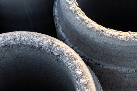 Concrete pipes stacked and prepared for sewer construction. Industrial construction site showing materials for drainage and urban infrastructure developmentの写真素材