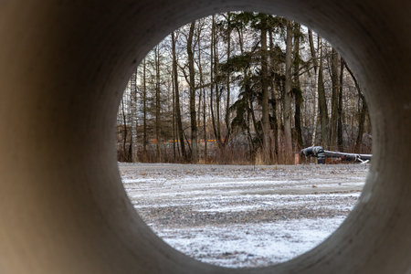 Concrete pipes stacked and prepared for sewer construction. Industrial construction site showing materials for drainage and urban infrastructure developmentの写真素材