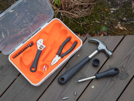 A compact, open orange tool kit rests on a wood deck, symbolizing the ease of DIY and home repair....