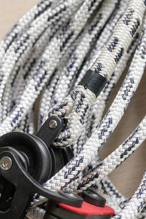 Close-up photo of a coiled double-braided marine polyester halyard in white with black tracers,...