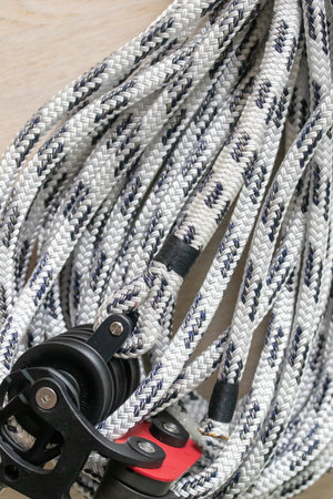 Close-up photo of a coiled double-braided marine polyester halyard in white with black tracers,...