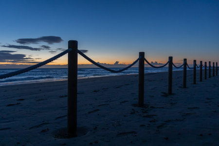 Protected dunes at El Moncayo Beach in Guardamar del Segura, Spain, fine sand. Wooden walkways and rope fencing guide visitors, prevent erosion, and protect fragile coastal ecosystemsの写真素材