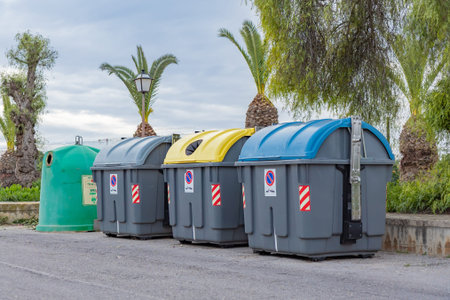 Color-coded waste and recycling bins in Spain help residents sort household waste. Yellow lids are...