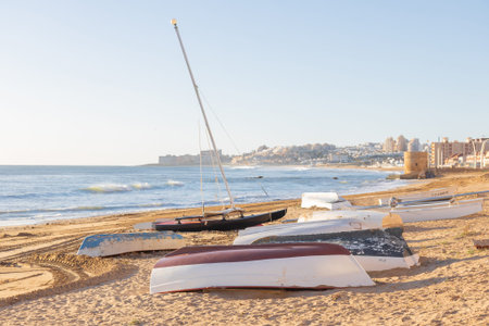 A serene coastal scene in Spain featuring sunken boats on the sand near the Mediterranean Sea.