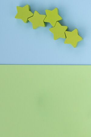 Kids toys on pastel blue green paper background. Top view on children's educational games. Wooden stars. Flat lay, copy space.の写真素材