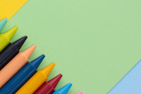 Back to school, minimalism concept. School supplies. Wax crayons on trendy blue green yellow color paper background. Copy space, flat layの写真素材