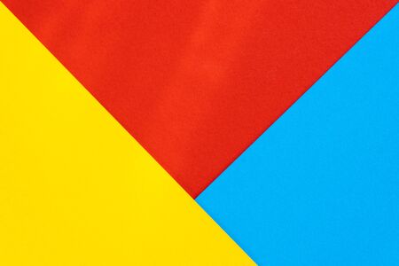 Yelllow blue red color paper background. Geometric figures, shapes. Abstract geometric flat composition. Empty space on monochrome cardboard.の写真素材