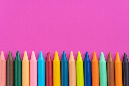 Back to school, minimalism concept. School supplies. Wax crayons on trendy purple color paper background. Copy space, flat layの写真素材