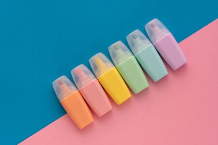 Highlighters set on colored blue pink background. Collection of markers different color. Flat lay, top view. Back to school, education concept.の写真素材