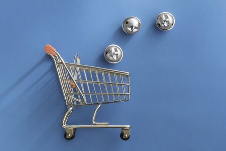 New Year or Christmass toys in trolley shopping cart on colorful blue background. Delivery service....
