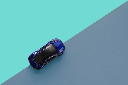Kids toy car on trendy colorful background. Baby blue car top view on double colored blue paper. Boys game. Travel and sport lifestyle. Business, transportation concept.の写真素材