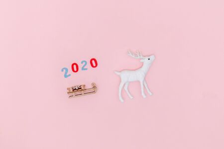 New year 2020, Christmas frame, greeting card. White deer with Santa's sleigh on pastel pink paper...
