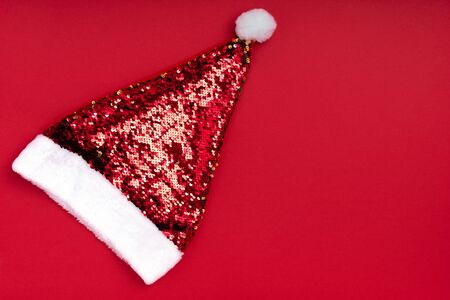 Christmas sparkling Santa Claus hat on red background. Christmas xmas new year holiday background....