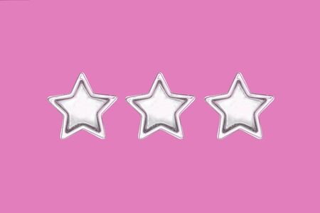 Christmas three five pointed golden stars on pink background. Christmas shining decoration. Holiday...