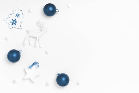 New Year and Christmas composition. Frame from blue balls, stars, chrismas tree, deer on white background. Top view, flat lay, copy space. Trendy color of the year 2020.の写真素材