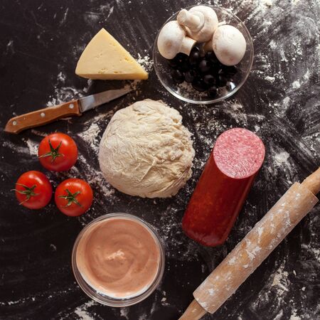 Food concept. Fresh original Italian raw pizza, preparation in traditional style. Making pizza at home. Pizza cooking in a real home interiorの写真素材