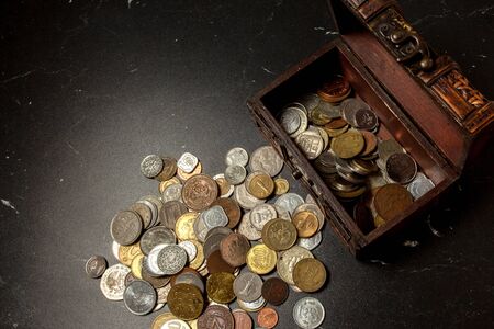 old coins collection in an ancient wooden chest boxの写真素材