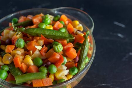 healthy food steamed vegetables on plate at dark backgroundの写真素材