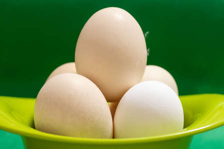 eggs in a green plate folded in the form of a pyramid on a green background. Close-up. Selective...