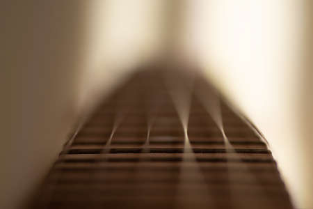 Closeup detail of steel guitar strings and frets for making music. Selective focus on one guitar threshold.の写真素材