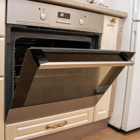 Empty open electric oven with hot air ventilation. New stove. The door is open and the lights are off.の写真素材