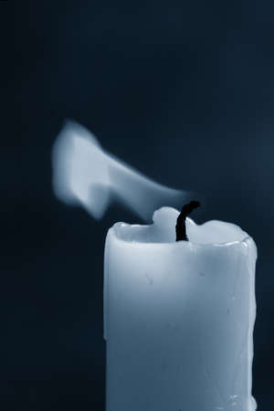 flame blue candle on a dark blue background, close-up, frozen flame. Classic blue, trend 2020.の写真素材