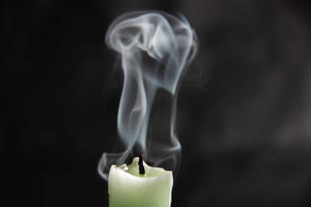 extinct light green candle with spectacular abstract smoke on a black background, close-up, abstraction.の写真素材