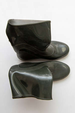 Dark crumpled rubber boots stand, isolated forn, close-up.の写真素材