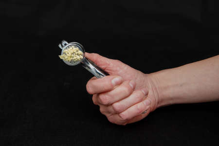 Useful garlic syrup squeezed with a kitchen juicer. Natural treatments for colds. Close-up, dark background.の写真素材